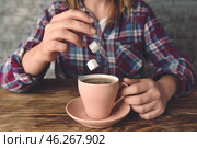 Woman dropping sugar cubes into cup with hot coffee at table, closeup. Стоковое фото, фотограф Pixel_shot / Фотобанк Лори