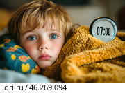 Симпатичный мальчик в постели, проснулся по будильнику, пора вставать, на часах 07:00. Стоковое AI-изображение, AI-художник Щеголева Ольга / Фотобанк Лори