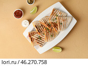 Plate with tasty quesadillas, lime, sauce and pickled jalapenos on color background. Стоковое фото, фотограф Pixel_shot / Фотобанк Лори