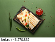 Board with tasty vegetarian quesadillas, chili peppers and sauce on color background. Стоковое фото, фотограф Pixel_shot / Фотобанк Лори