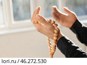 Young Muslim man with rosary beads praying at home, closeup. Стоковое фото, фотограф Pixel_shot / Фотобанк Лори