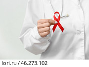 Young female doctor with red ribbon on white background, closeup. AIDS Day concept. Стоковое фото, фотограф Pixel_shot / Фотобанк Лори