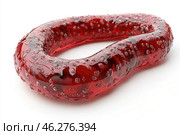 An abstract figure in the form of a deformed torus (closed ring). The object is made of a translucent red material resembling glass or gel, with bubbles or crystals on its surface. The texture looks glossy and smooth, creating the effect of depth and inner glow. The white background emphasizes the brightness and saturation of the red color, giving the object a futuristic and organic look. Стоковое AI-изображение, AI-художник Анна Кривицкая / Фотобанк Лори