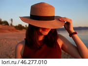 Portrait of an attractive girl in a straw hat on a sandy beach at sunset. Стоковое фото, фотограф Виктория Тельминова / Фотобанк Лори