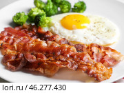 Fried bacon rashers and egg on plate, closeup. Стоковое фото, фотограф Pixel_shot / Фотобанк Лори