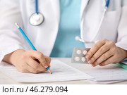 Female doctor with pills writing in clinic. Стоковое фото, фотограф Pixel_shot / Фотобанк Лори