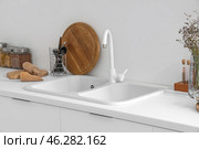 White counters with sink and utensils in interior of modern kitchen, closeup. Стоковое фото, фотограф Pixel_shot / Фотобанк Лори