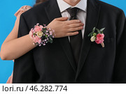 Young woman with corsage hugging her prom date on blue background, closeup. Стоковое фото, фотограф Pixel_shot / Фотобанк Лори