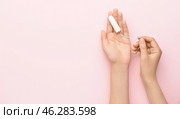Female hands with menstrual tampon on pink background. Стоковое фото, фотограф Pixel_shot / Фотобанк Лори