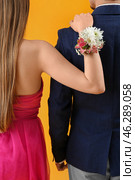 Young girl with corsage and her prom date on yellow background, back view. Стоковое фото, фотограф Pixel_shot / Фотобанк Лори