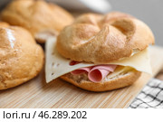 Kaiser rolls with ham and cheese on wooden board. Стоковое фото, фотограф Pixel_shot / Фотобанк Лори