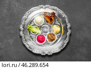 Passover Seder plate with traditional food on dark background. Стоковое фото, фотограф Pixel_shot / Фотобанк Лори