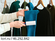 Woman cleaning clothes with lint roller on brick background. Стоковое фото, фотограф Pixel_shot / Фотобанк Лори