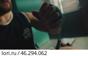 Boxer Wraps Hands in Dimly Lit Locker Room. Редакционное видео, видеограф Михаил Матвеев / Фотобанк Лори