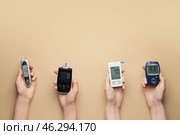 Female hands with different glucometers on color background. Diabetes concept. Стоковое фото, фотограф Pixel_shot / Фотобанк Лори