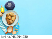 Potato pancakes and dreidels for Hanukkah with kipa on color background. Стоковое фото, фотограф Pixel_shot / Фотобанк Лори