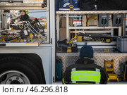 Сотрудник МЧС России разбирает инструменты в специальном автомобиле службы спасения в городе Москве, Россия. Редакционное фото, фотограф Николай Винокуров / Фотобанк Лори