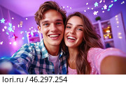 A happy young couple takes a selfie against the backdrop of bright garlands and sparkling snowflakes, conveying an atmosphere of joy, coziness and festive mood. Стоковое AI-изображение, AI-художник ArtVladZ / Фотобанк Лори