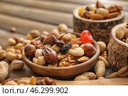 Bowls with various tasty nuts on wooden table. Стоковое фото, фотограф Pixel_shot / Фотобанк Лори