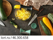 Fresh zucchini spaghetti with spiral grater and vegetables on dark table. Стоковое фото, фотограф Pixel_shot / Фотобанк Лори
