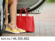 Young woman with pain in legs because of uncomfortable shoes sitting in car. Стоковое фото, фотограф Pixel_shot / Фотобанк Лори