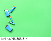 Alkaline batteries on green background, top view. Стоковое фото, фотограф Pixel_shot / Фотобанк Лори