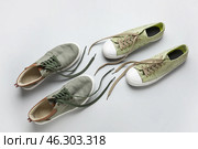 Two pairs of stylish shoes with untied laces on white background. Стоковое фото, фотограф Pixel_shot / Фотобанк Лори