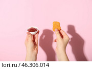 Woman holding tasty nugget and bowl of ketchup on pink background. Стоковое фото, фотограф Pixel_shot / Фотобанк Лори