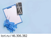 Clipboard with medical gloves, gynecological speculum and pap smear test tools on blue background. Стоковое фото, фотограф Pixel_shot / Фотобанк Лори