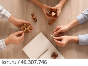 Young people with brain teasers at wooden table. Стоковое фото, фотограф Pixel_shot / Фотобанк Лори