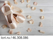 Ballet shoes with flower petals on wooden floor. Стоковое фото, фотограф Pixel_shot / Фотобанк Лори