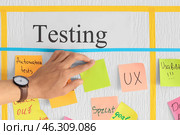 Man attaching sticky note to scrum task board in office. Стоковое фото, фотограф Pixel_shot / Фотобанк Лори