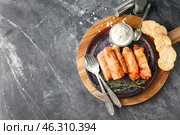 Plate with stuffed cabbage leaves and bowl of sour cream on wooden board. Стоковое фото, фотограф Pixel_shot / Фотобанк Лори