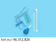 Gynecological speculum with pap smear test tools and enema on blue background. Стоковое фото, фотограф Pixel_shot / Фотобанк Лори