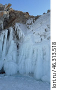 Vertical video of Baikal Lake. Unusual landscape with icy cliffs of Olkhon Island on cold February day. Beautiful long icicles on rocky shore attract tourists. Winter adventures and active recreation. Стоковое видео, видеограф Виктория Катьянова / Фотобанк Лори