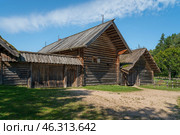 View of an ancient log building on the territory of the Pushkin village in Bugrovo of the Pushkin Museum-Reserve on a sunny summer day, Pushkinskiye Gory, Pskov region, Russia. Стоковое фото, фотограф Ula Ulachka / Фотобанк Лори