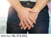Мужчина стоит, скрестив руки перед собой на уровне паха. Стоковое фото, фотограф Valeryi Vysotkov / Фотобанк Лори