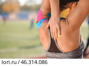Sporty woman with physio tape applied on body at stadium, closeup. Стоковое фото, фотограф Pixel_shot / Фотобанк Лори