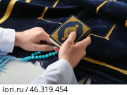 Muslim man with Koran and tasbih praying at home. Стоковое фото, фотограф Pixel_shot / Фотобанк Лори