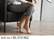 Barefoot businesswoman sitting in armchair at home. Стоковое фото, фотограф Pixel_shot / Фотобанк Лори