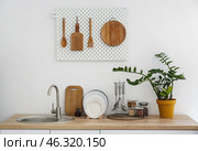 Wooden counter with kitchenware and pegboard with utensils on light wall. Стоковое фото, фотограф Pixel_shot / Фотобанк Лори