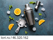 Strainer, cocktail shaker, double jigger and ingredients on dark background. Стоковое фото, фотограф Pixel_shot / Фотобанк Лори