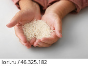Hands of elderly woman with rice on white background. Concept of poverty. Стоковое фото, фотограф Pixel_shot / Фотобанк Лори
