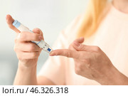 Diabetic woman taking blood sample with lancet pen at home, closeup. Стоковое фото, фотограф Pixel_shot / Фотобанк Лори