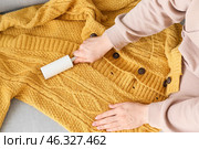 Woman cleaning knitted sweater with lint roller, closeup. Стоковое фото, фотограф Pixel_shot / Фотобанк Лори