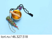 Tibetan singing bowl, beads and herbs on color background. Стоковое фото, фотограф Pixel_shot / Фотобанк Лори