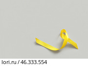 Yellow ribbon on light background. Sarcoma concept. Стоковое фото, фотограф Pixel_shot / Фотобанк Лори