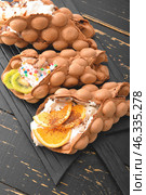 Delicious sweet bubble waffles on dark wooden background. Стоковое фото, фотограф Pixel_shot / Фотобанк Лори