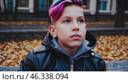 Young boy with dyed hair looking around in autumn. Стоковое видео, видеограф Данил Руденко / Фотобанк Лори