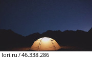 Illuminated tent under starry night sky in mountains. Стоковое видео, видеограф Данил Руденко / Фотобанк Лори
